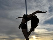 Girls in leaf bikinis perform pole dance on the beach