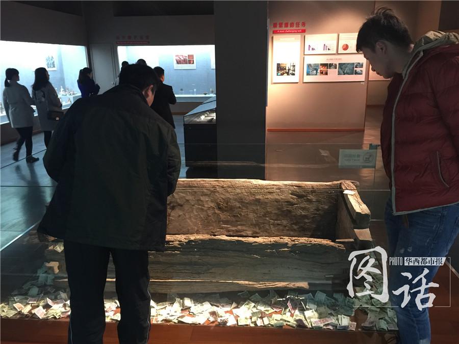 Human remains in museum covered by coins and banknotes thrown by tourists