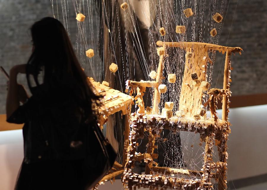 A visitor walks past an artwork at the 7th International Fiber Art Biennale and Symposium in Nantong, east China's Jiangsu Province, Nov. 12, 2012. More than 300 artworks from 37 countries and regions were displayed during the exhibition, which was slated from Nov. 8 to Dec. 5. (Xinhua/Huang Zhe) 