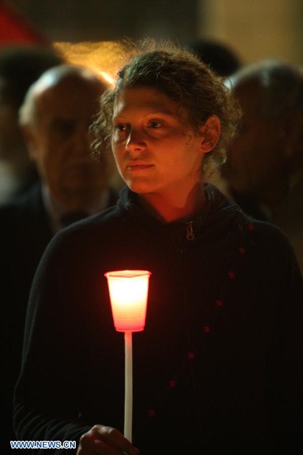 An activist holds a candle during a solidarity protest near the Church of the Nativity in the West Bank city of Bethlehem on Nov. 14, 2012. Several Palestinians were killed following a series of Israel's concurrent airstrikes on Gaza city, among them was Ahmed al-Jaabari, top commander of Hamas armed wing Al-Qassam brigades, and more than 40 others wounded, government's emergency services in the Gaza Strip said. (Xinhua/Luay Sababa)