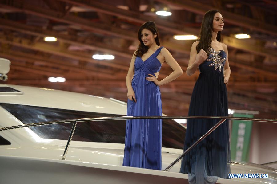 Models present a yacht during the 2012 Macao Yacht Show in Macao, south China, Nov. 16, 2012. More than 30 yacht exhibitors take part in the three-day yacht show, which kicked off here on Friday. (Xinhua/Cheong Kam Ka)