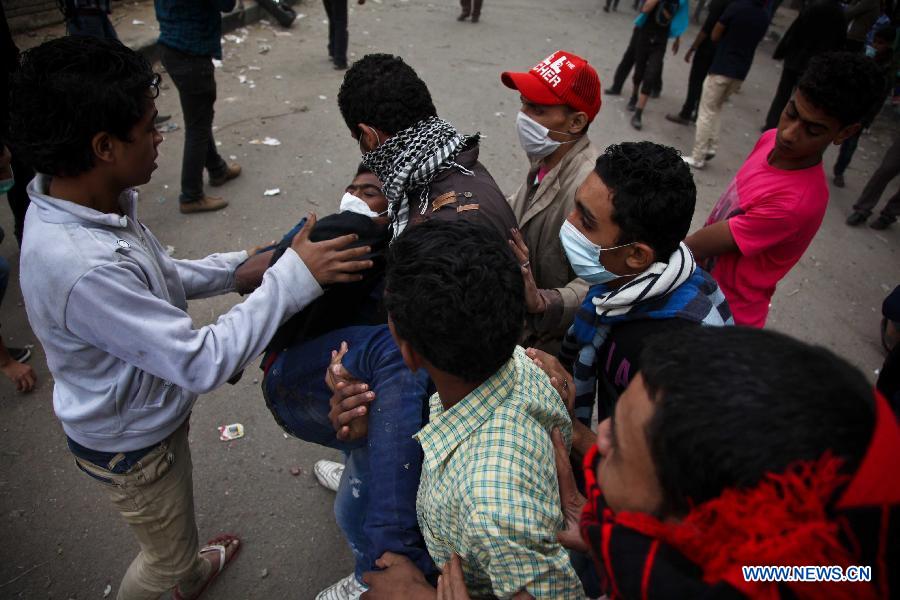 Egyptian protesters help an injured protester during clashes with police near the U.S. Embassy in central Cairo, Egypt, Nov. 27, 2012. Egyptian people flooded to the capital Cairo's central Tahrir Square on Tuesday to join a rally rejecting the new constitutional declaration issued by President Mohamed Morsi last Thursday. (Xinhua/Amru Salahuddien) 