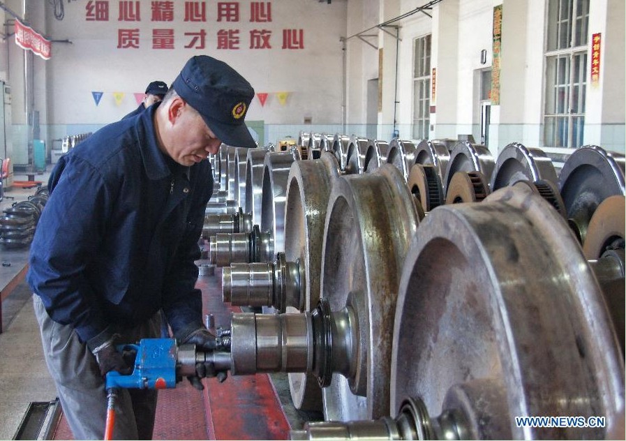 A worker of the Baotou vehicle section of the Hohhot Railway Bureau assembles wheel sets in Baotou, north China's Inner Mongolia Autonomous Region, Nov. 29, 2012. Facing the low temperatures, strong winds and snowfalls since winter, the Hohhot Railway Bureau has organized all its departments to guarantee the rail transport in winter, including activities like strengthening vehicle scheduling and security inspection during on-site operations. (Xinhua/Zhao Tingting) 