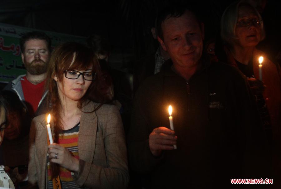 People light candles around the destroying house of Al-Dalou family in Gaza City on Dec. 1, 2012. An Israeli bomb fell upon Al-Dalou family's two-storey house in Gaza City's residential al-Nasser neighborhood on Nov.18, killing 11, including four children and a woman as old as 81. It was one of the deadliest events in the latest conflict between Israel and Gaza militants. (Xinhua/Yasser Qudih)