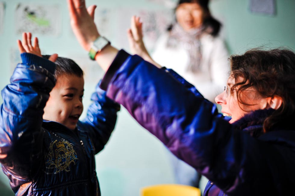 Dorothee Brutzer (R) gives language training for a disabled boy at a rehabilitation training center in Changsha, capital of central China's Hunan Province, Feb. 8, 2012.(Xinhua/Bai Yu) 