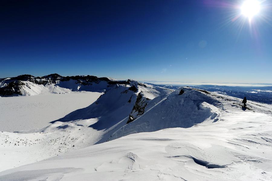 A tourist climbs next to the Tianchi Lake on the snow-covered Changbai Mountain in Yanbian Korean Autonomous Prefecture, northeast China's Jilin Province, Dec. 19, 2012. (Xinhua/Zhang Nan) 