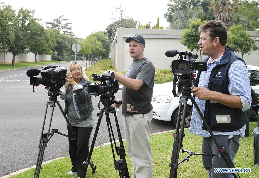 Media workers wait outside the residence of former South African president Nelson Mandela in Johannesburg, South Africa, on Dec. 18, 2012. South African President Jacob Zuma said on Tuesday that doctors are satisfied with the progress former president Nelson Mandela is making during his treatment. (Xinhua/Li Qihua) 