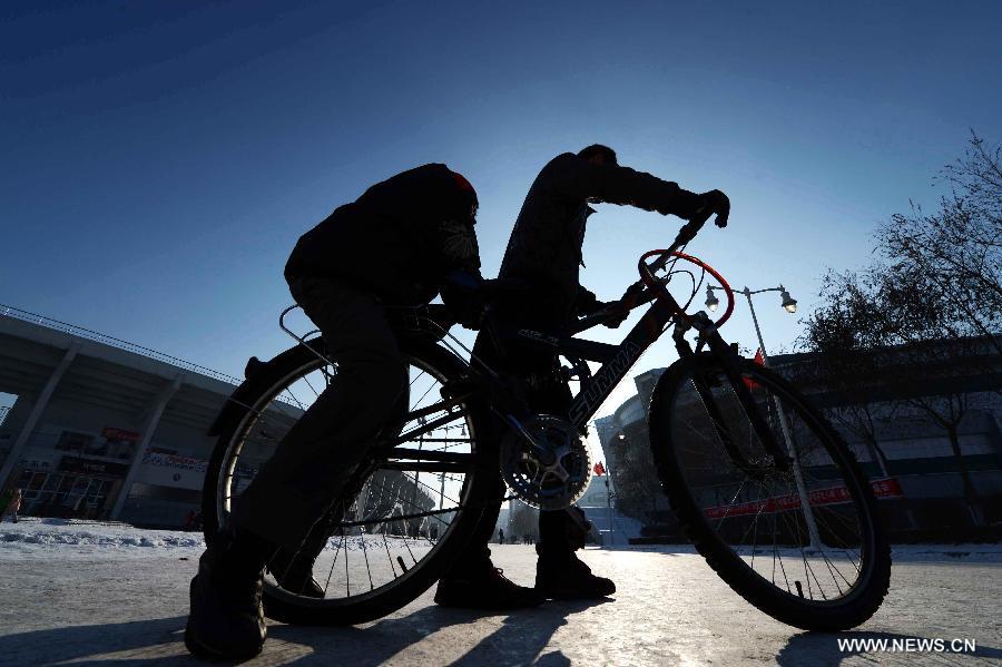 Wang Junsheng (R) drives his disabled classmate Jiang Jian on a bicycle to the classroom at school in Harbin, capital of northeast China's Heilongjiang Province, Dec. 19, 2012.