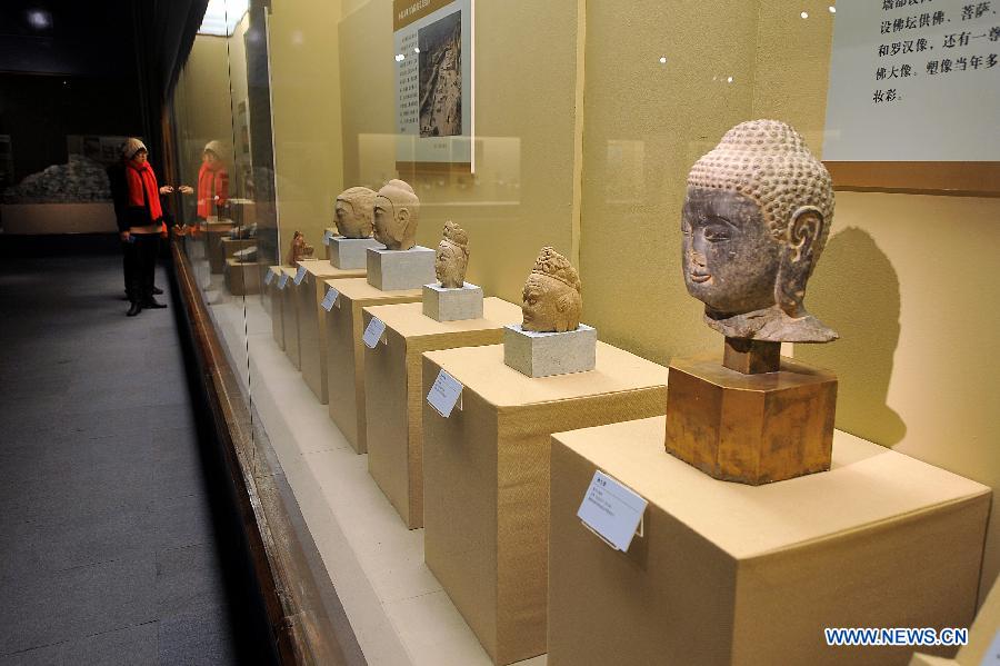 Visitors look at the exhibits at the Shanxi Museum in Taiyuan, capital of north China's Shanxi Province, Dec. 25, 2012. The "footprints of civilization" exhibition was held at the Shanxi Museum on Tuesday, showing some 300 items of antiques highlighting the achievements of the Archeology Institute of the Chinese Academy of Social Sciences. (Xinhua/Zhan Yan) 