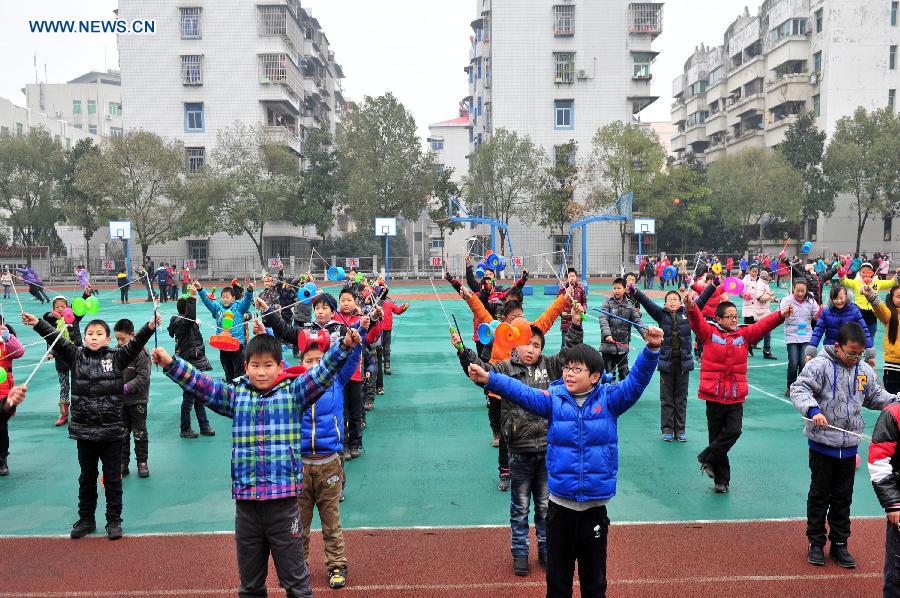 Pupils play traditional Kongzhu, also known as diabolo, at the playground of the Zigui experimental primary school in Zigui County, central China's Hubei Province, Dec. 27, 2012. Kongzhu literarily means empty bamboo, and is one of the major Chinese traditional toys along with shuttlecocks and kites. It is a popular activity among people of various ages. (Xinhua/Wang Huifu)