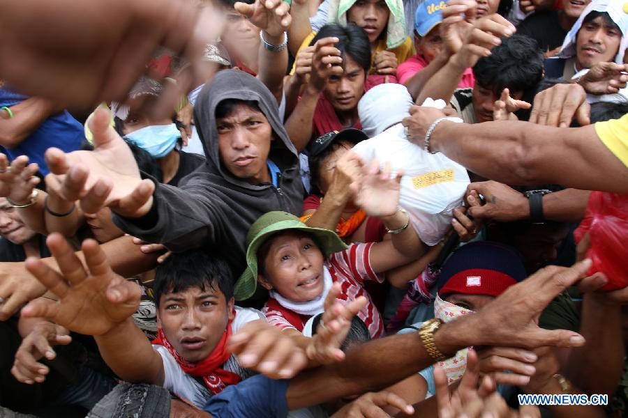 Typhoon-affected residents wait for relief food in a heavily damaged town of New Bataan of Compostela Valley Province, the Philippines, Dec. 9, 2012. The death toll from Typhoon Bopha has climbed to 540 and 827 others are still missing, official statistics released Sunday showed. (Xinhua/JEMA)