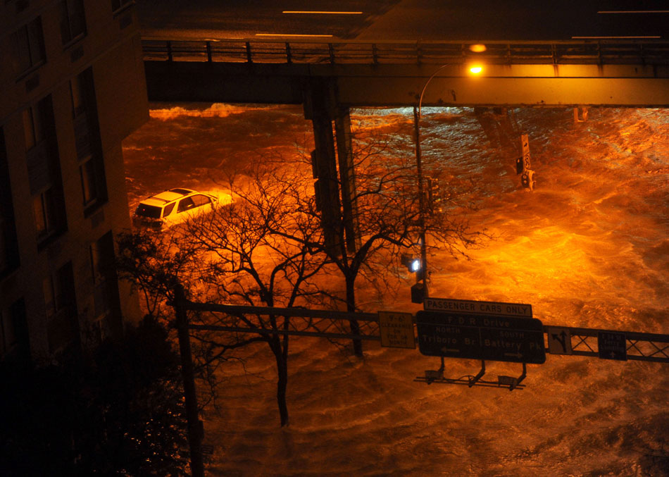 A car is submerged in a street of Manhattan on Oct. 29. Hurricane Sandy flooded streets, leaving many parts of the New York City in the darkness. (Xinhua/Shen Hong)