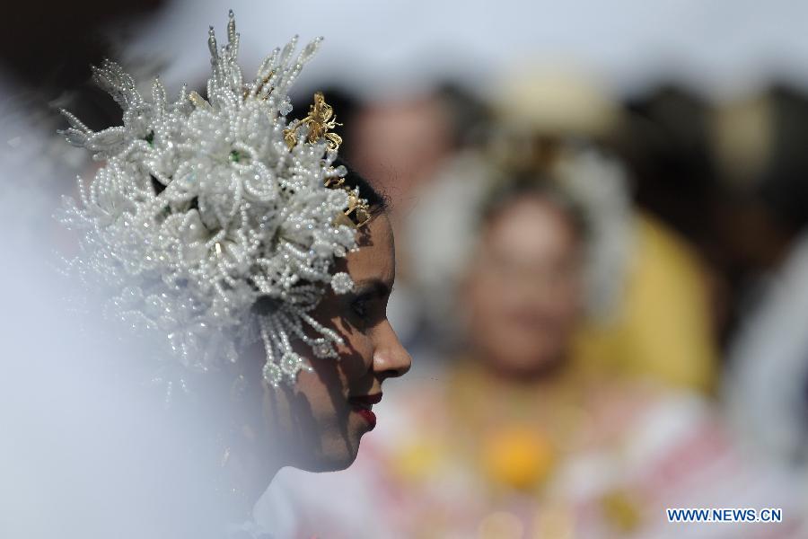 A woman wearing the traditional dress of Pollera participates in the Parade of 1,000 Polleras in Las Tablas, Panama, on Jan. 12, 2013. Polleras are traditional handmade costumes worn by Panamanian women mostly in folklore festivities. According to parade organizers, almost every part of the costume is made by hand and the assortment of head, neck and chest jewelry worn with a pollera can cost as much as 20,000 U.S. dollars. (Xinhua/Mauricio Valenzuela)