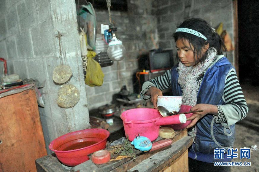 Li Azuo clears up the dishes after meal in a village in Guangxi on Jan. 8, 2013. (Xinhua/Zhou Hua)