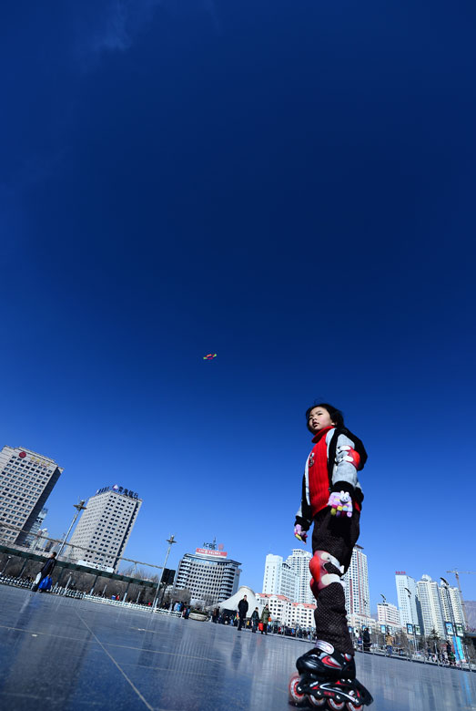 A boy roller skates in a square under the clean blue sky in Xining, northwest China’s Qinghai province, Jan. 13, 2012. (Xinhua/Zhang Hongxiang)