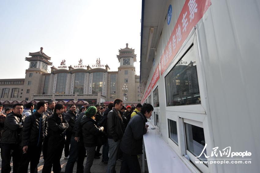 Homecoming people buy train ticket with anxiety outside a temporary ticket booth set at Beijing Railway Station, Jan. 22. The Spring Festival travel peak is going to begin on Jan. 26 and will last about 40 days. Railway passenger trips are expected to hit 225 million during the upcoming travel peak. (People’s Daily Online/Weng Qiyu)