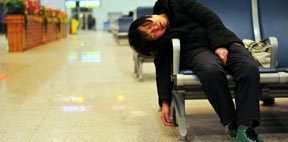 A women falls asleep in the waiting hall of the railway station. 