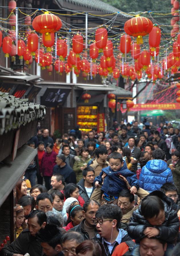 Tourists are seen on a street of the Ciqikou Town in southwest China's Chongqing Municipality, Feb. 13, 2013. Large amount of tourists visited the time-honored Ciqikou during the Spring Festival holiday. (Xinhua/Liu Chan) 