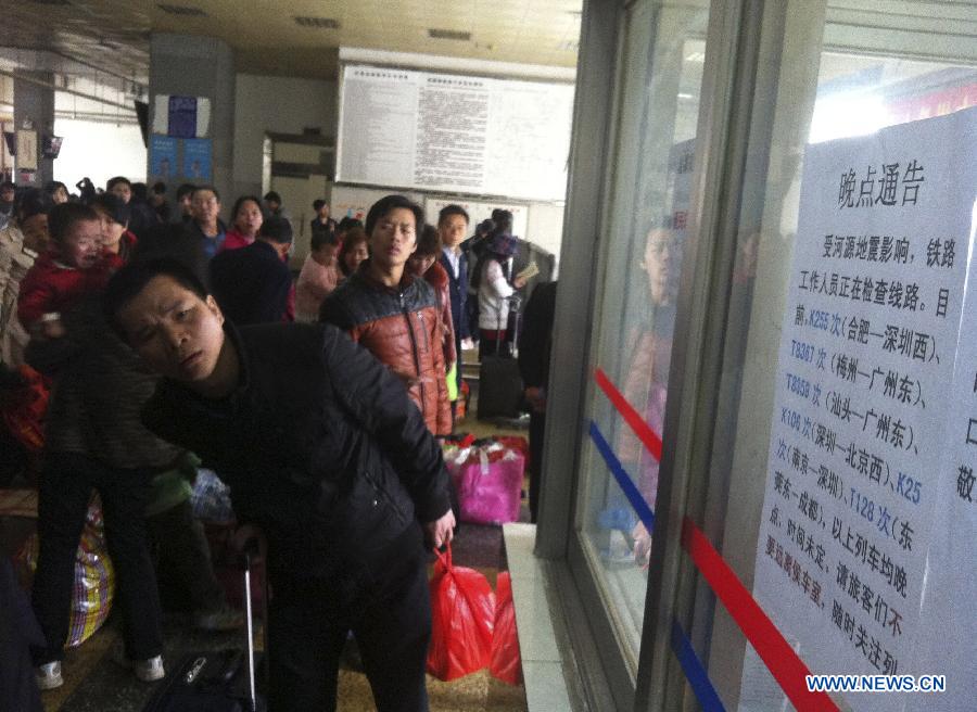 Passengers gather to watch a notice about trains delay due to the 4.8-magnitude earthquake at Heyuan Railway Station in Heyuan City, south China's Guangdong Province, Feb. 22, 2013. A 4.8-magnitude quake jolted Heyuan City in Guangdong Province at 11:34 a.m. Friday (Beijing Time), according to the China Earthquake Networks Center. The epicenter, with a depth of 11 km, was monitored at 23.9 degrees north latitude and 114.5 degrees east longitude, the center said. Affected by the earthquake, most trains here were delayed and many passengers were detained at the railway station. (Xinhua/Tan Xingfu) 