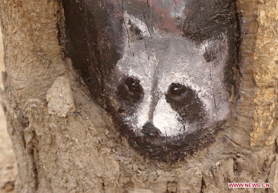 A tree hollow painting is seen at Jiuzhong street in Shijiazhuang, capital of north China's Hebei Province, Feb. 24, 2013. Paintings in shade tree hollows by Wang Yue, a local art student, became an Internet sensation lately. (Xinhua/Ding Lixin)