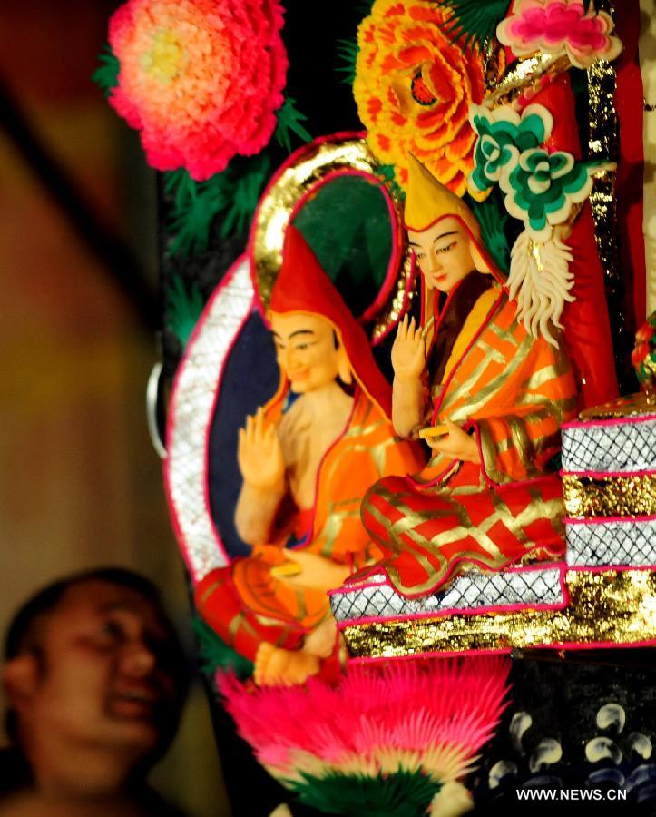 A Buddhist monk views yak butter sculptures displayed at the Labrang Monastery in Xiahe County of Gannan Tibetan Autonomous Prefecture, northwest China's Gansu Province, Feb. 24, 2013. An annual yak butter sculpture show was held here on Sunday, the Chinese Lantern Festival, as a means to pray for good fortune and harvest. The Labrang Monastery is among the six great monasteries of the Geluk school of Tibetan Buddhism. (Xinhua/Zhang Meng) 