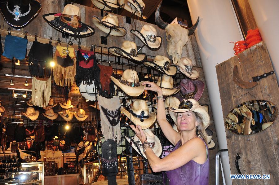 A woman shows some cowboy hat in Houston, the United States, Feb. 28, 2013. Houston Live Stock Show and Rodeo is held during Feb. 25 to March 17 in Reliant Park in Houston, which is a city of rodeo culture. The rodeo was held yearly since 1932, and has become the biggest rodeo in the world. (Xinhua/Zhang Yongxing)