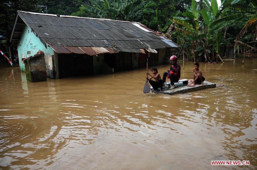  People use a boat to across the flooded area in Cawang, East Jakarta, Indonesia, March 5, 2013. The National Disaster Mitigation Agency (BNPB) on Tuesday warned that Jakarta could experience another big flood this week, as many areas in the city have already been swamped after the water level at Bogor's Katulampa dam reached 250 centimeters on Monday. 