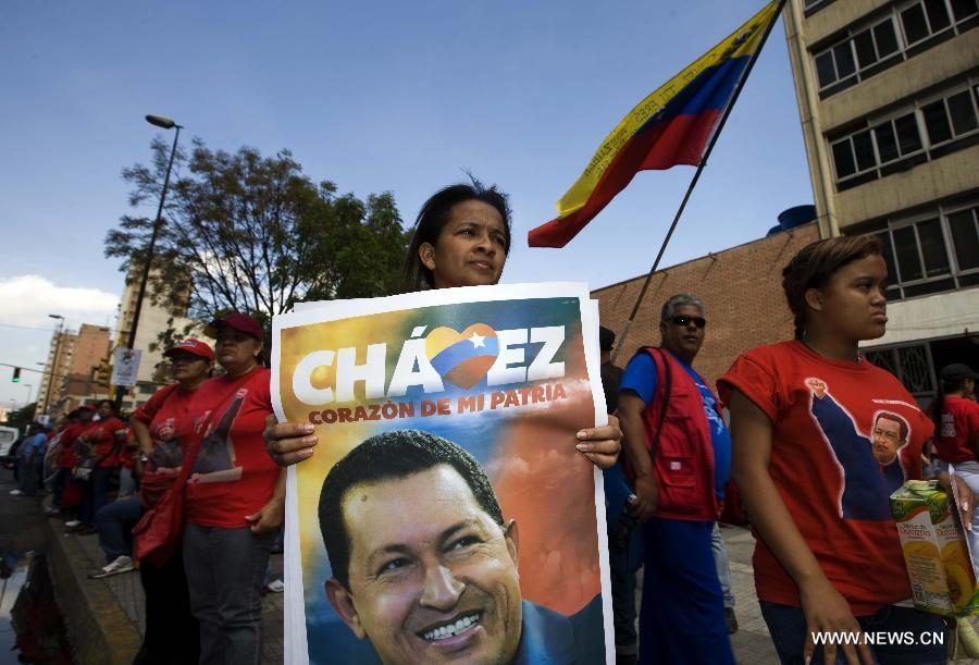 Residents participate in the funeral procession in honor of Venezuelan President Hugo Chavez on the streets of Caracas, capital of Venezuela, on March 6, 2013. On Tuesday afternoon, Venezuelan President, Hugo Chavez, died after fighting for almost two years with a cancer disease. The body of Chavez is moved from the health center to the Military Academy in southern Caracas, inside Tiuna's Fort. (Xinhua/David de la Paz)