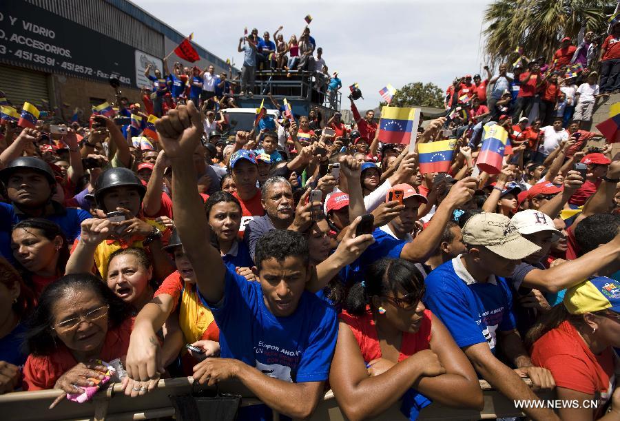 Residents participate in the funeral procession in honor of Venezuelan President Hugo Chavez on the streets of Caracas, capital of Venezuela, on March 6, 2013. On Tuesday afternoon, Venezuelan President, Hugo Chavez, died after fighting for almost two years with a cancer disease. The body of Chavez is moved from the health center to the Military Academy in southern Caracas, inside Tiuna's Fort. (Xinhua/David de la Paz)