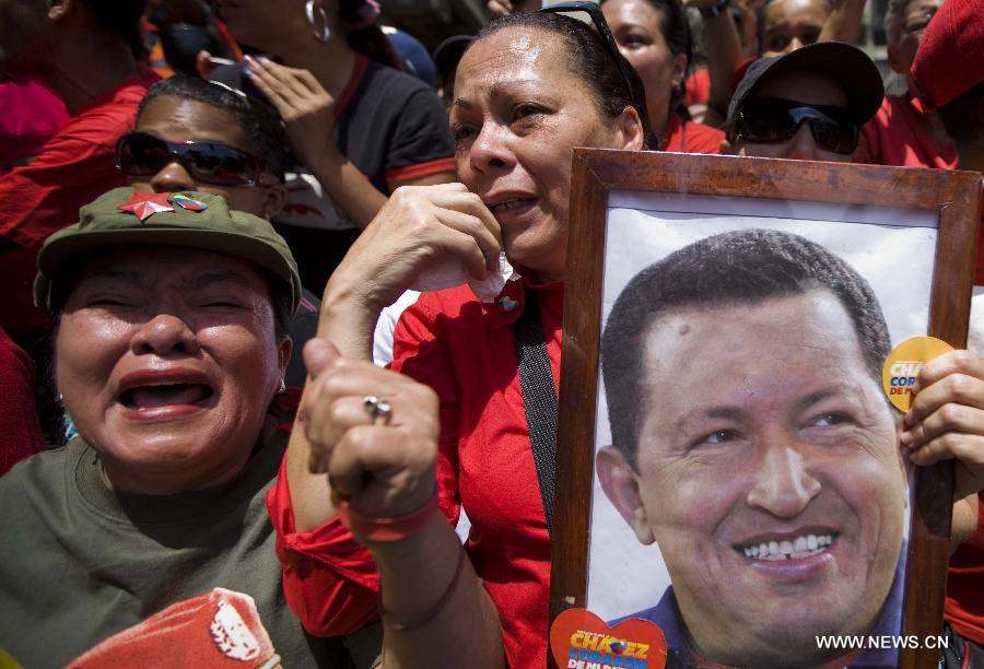 Residents participate in the funeral procession in honor of Venezuelan President Hugo Chavez on the streets of Caracas, capital of Venezuela, on March 6, 2013. On Tuesday afternoon, Venezuelan President, Hugo Chavez, died after fighting for almost two years with a cancer disease. The body of Chavez is moved from the health center to the Military Academy in southern Caracas, inside Tiuna's Fort. (Xinhua/David de la Paz)