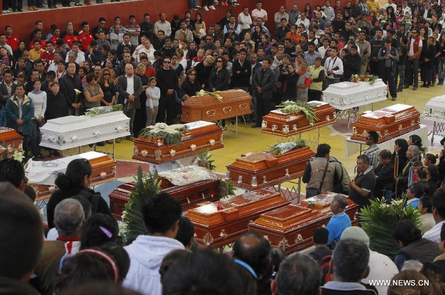 Relatives and friends attend a mass funeral for victims of a fireworks accident at the village of Nativitas in Tlaxcala state, Mexico, on March 17, 2013. At least 13 people were killed and 154 others injured when a truck containing fireworks exploded during a Catholic procession in honor of a local patron saint. (Xinhua/Juan Mateo) 