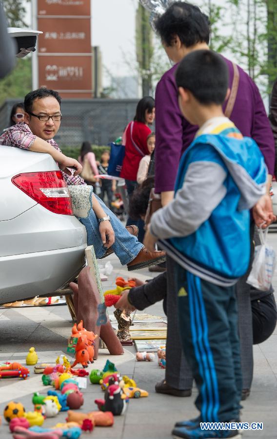 Shoppers choose old toys at a weekend trunk market held by a local auto club at Beibin Road in Chongqing, southwest China's municipality, March 23, 2013. (Xinhua/Chen Cheng) 