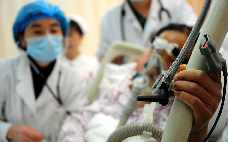 Liu Xiaoli (first from left), director of maternal trauma center in Lanzhou, treat a critically ill patient with her colleagues on March 25, 2013. (Xinhua/Zhang Meng)