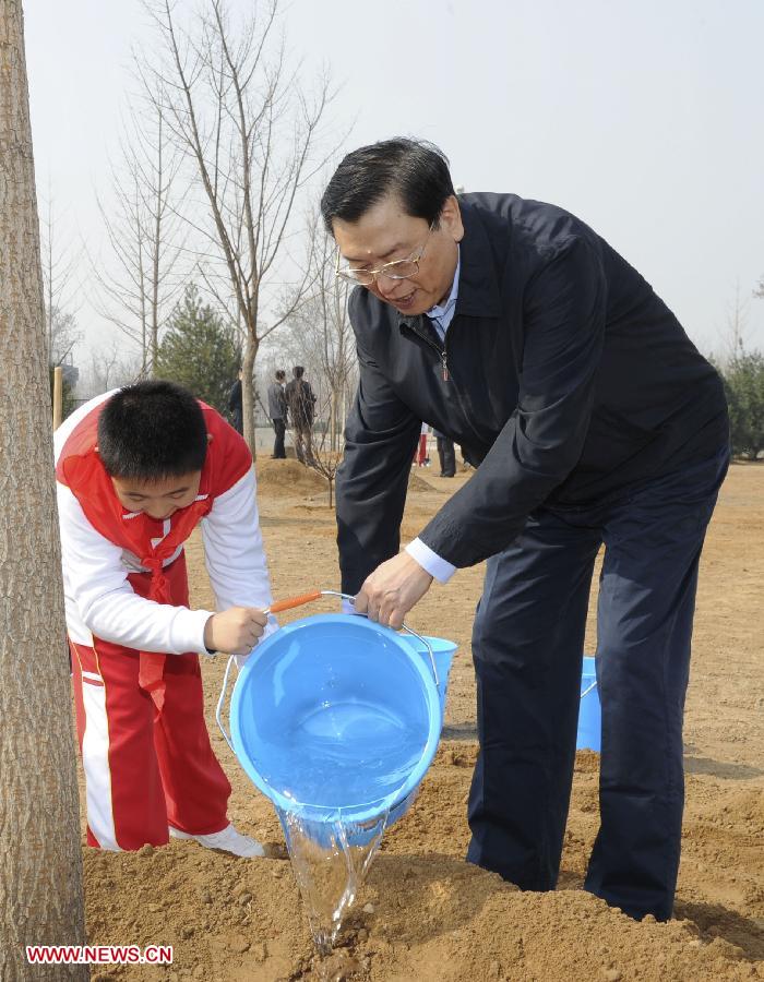 Zhang Dejiang (R) waters a tree together with a pupil during a tree-planting event in Fengtai District in Beijing, capital of China, April 2, 2013. Chinese top leaders Xi Jinping, Li Keqiang, Zhang Dejiang, Yu Zhengsheng, Liu Yunshan, Wang Qishan and Zhang Gaoli joined in the tree planting event here on Tuesday. (Xinhua/Rao Aimin)