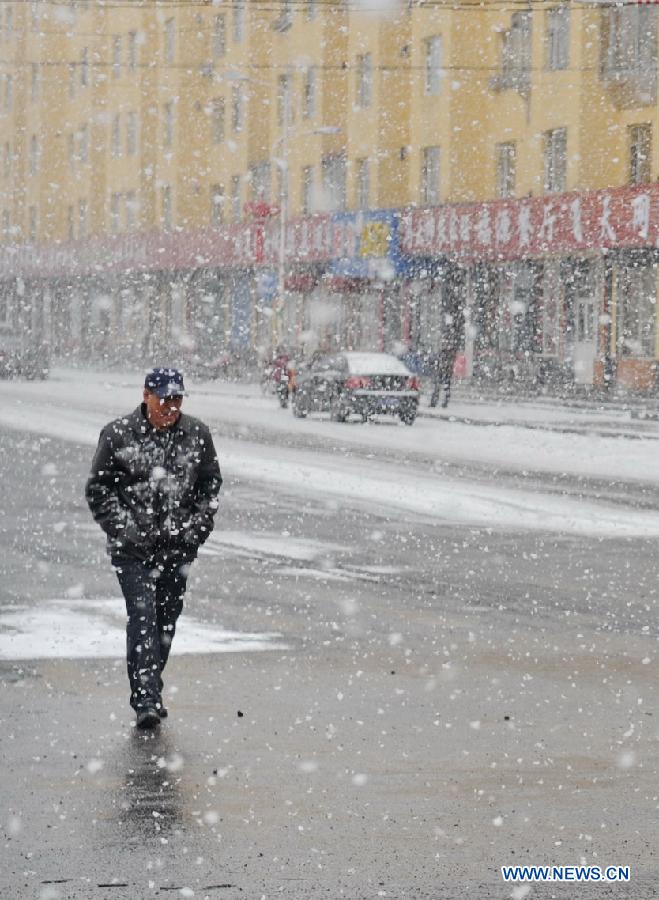 A citizen rides in snow in Baishan City, northeast China's Jilin Province, April 9, 2013. (Xinhua/Zhang Nan) 