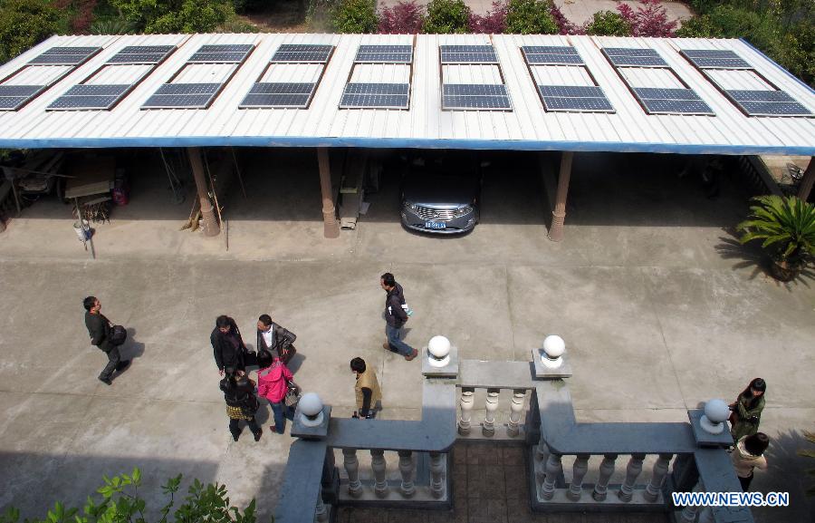 Photo taken on April 8, 2013 shows solar panels of a homemade photovoltaic power station made by a local resident named Mo Zhikai in Wumeng Village of Ningbo City, east China's Zhejiang Province.The 27-year-old Mo, an enthusiastic fan of photovoltaic power generation, installed over 70 solar panels with the capacity of 7.5 kilowatt on the roof of his own house and garage in 2009. Yet these panel were left unused as they were not allowed to be incorporated into the State Grid. Things changed as the State Grid Corporation of China released a document on Feb. 27, 2013, encouraging distributed generation to be incorporated into the State Grid. Staff members of Ningbo Power Bureau came to Mo's village for a survey of Mo's homemade photovoltaic power generation equipments on Monday. Mo will have the first homemade photovoltaic power station in Ningbo if everything goes smooth in 35 workdays. (Xinhua/Gong Guorong)