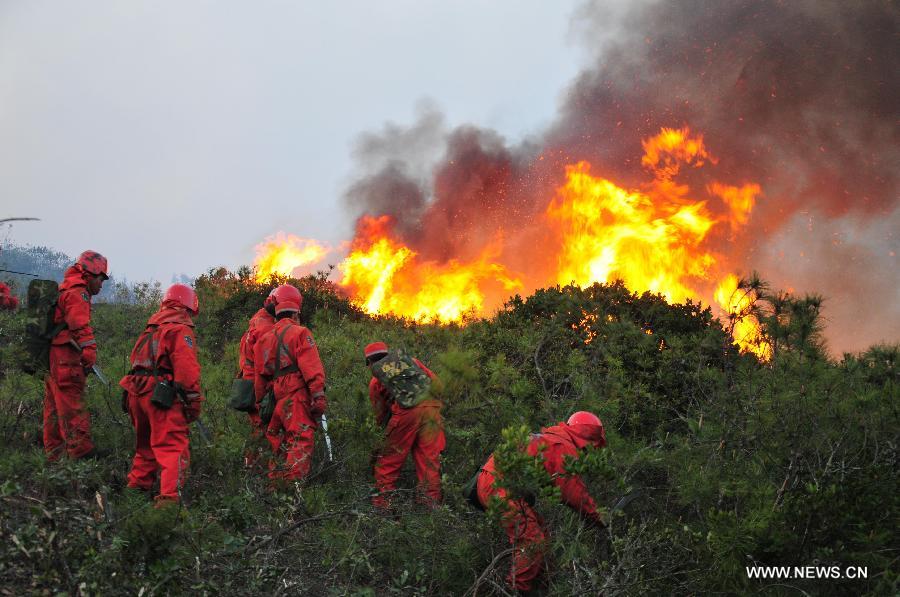 Forest policemen try to put out a forest fire in Anning, southwest China's Yunnan Province, April 9, 2013. The fire broke out around 1 p.m. (0500 GMT) in Anning City. Forest policemen and firefighters have been mobilized to quench the fire. (Xinhua/Zhong Yaojun)