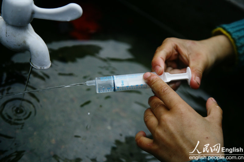 A disposable syringe without a needle becomes the younger son's toy, Nan'an city, Fujian, April 4, 2013. (CFP/Pan Deng)