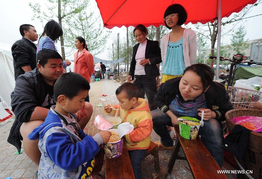 Residents have breakfast at a temporary shelter site in Luyang Township of Lushan County in Ya'an City, southwest China's Sichuan Province, April 21, 2013. Several temporary shelter sites can be seen in Lushan County and the life supplies in these shelter sites are sufficient. A 7.0-magnitude earthquake jolted Lushan County on April 20 morning. (Xinhua/Li Jian) 