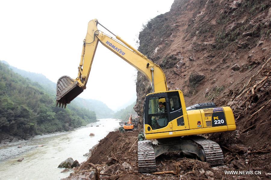 Armed police hydropower troops operate a bulldozer to repair a road leading to Baosheng Township, a worst quake-hit area, in Lushan County, southwest China's Sichuan Province, April 21, 2013. A 7.0-magnitude quake jolted Lushan County of Sichuan's Ya'an City at 8:02 a.m. Saturday Beijing Time, according to the China Earthquake Networks Center. Military and civilian rescue teams are struggling to reach every household in Lushan and neighboring counties. (Xinhua/Bai Xuefei) 