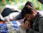 A mother tells stories to her child in a temporary tent 