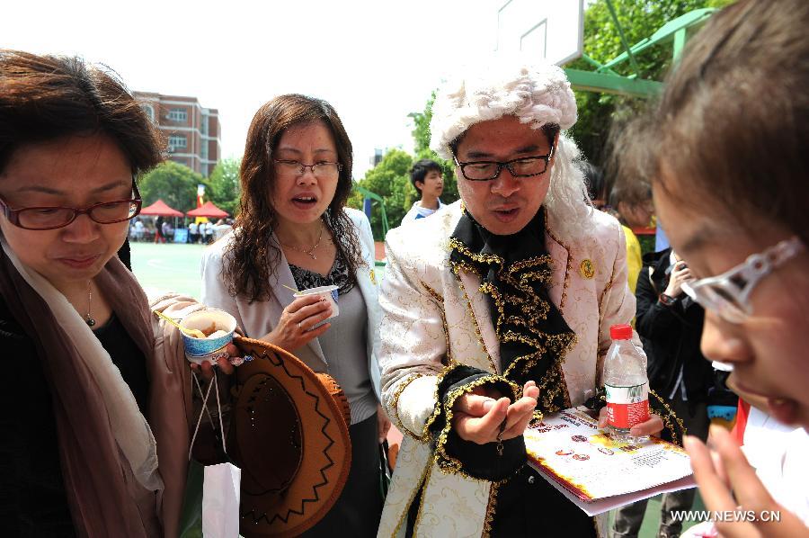 School principal Lu Zhenquan (2nd R) wears a wig during a costume parade in Tianyuan High School in Shanghai, east China, April 28, 2013. Teachers and students of the school dressed themselves as various real and fictional figures for a cross-culture costume parade here on Sunday. (Xinhua/Lai Xinlin) 