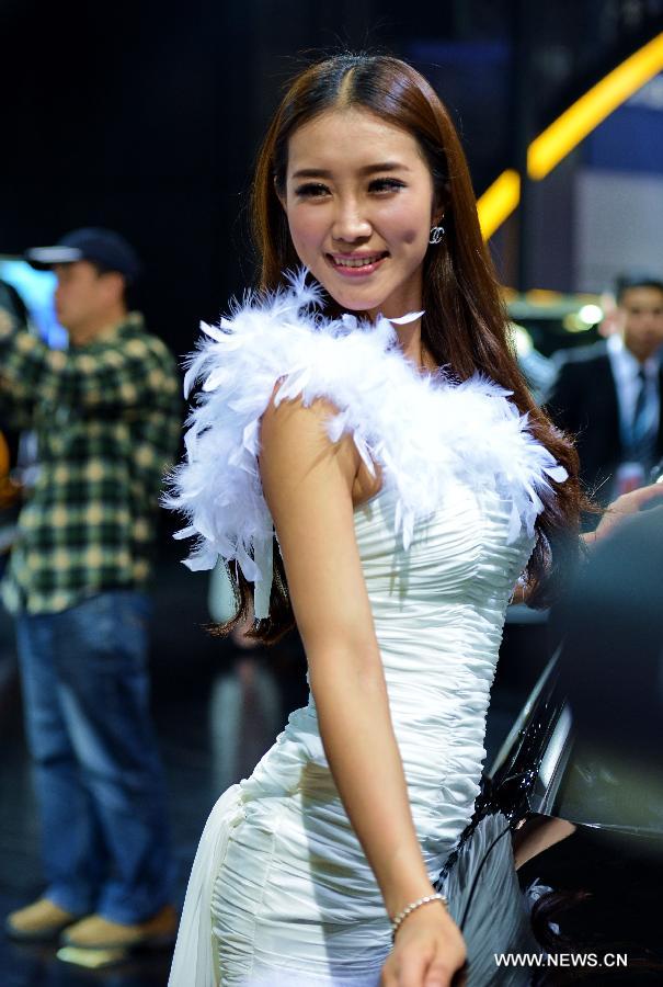 A model poses for photos with a sedan at Fuzhou Auto Fair in Fuzhou, capital of southeast China's Fujian Province, April 29, 2013. (Xinhua/Zhang Guojun)