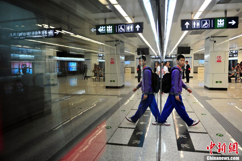 Passengers take Beijing Subway Line 10 on May 5, 2013. The last three stations were opened to complete the city's second loop subway line on Sunday. With 45 stations, the 57-kilometer line takes 104 minutes to make a complete loop, which makes it the longest completely underground subway line in the world.[Photo/CNS]