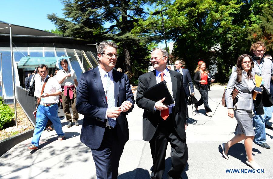 Roberto Azevedo (L) leaves after he was confirmed formally in Geneva, Switzerland, May 14, 2013. The World Trade Organization (WTO) on Tuesday formally appointed Roberto Azevedo as its new director general replacing Pascal Lamy, whose tenure will end on Aug. 31. (Xinhua/Wang Siwei)