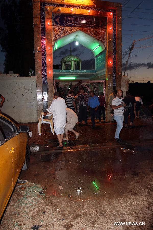 People clean the blast site at a Shiite mosque in Kirkuk, northern Iraq, May 16, 2013. At least 12 people were killed and 25 others injured as a suicide bomber blew himself up at a Shiite mosque in northern Iraq's Kirkuk on Thursday, local police sources said. (Xinhua/Dena Assad)