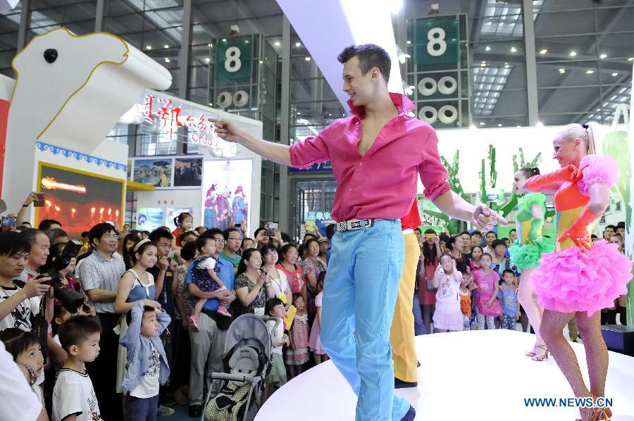 Performers dance during the 9th China (Shenzhen) International Cultural Industries Fair to attract visitors in Shenzhen, south China's Guangdong Province, May 19, 2013. The four-day event closed on Monday. The transaction volume in the first three days grew 15.85 percent year on year. (Xinhua/Liang Xu)