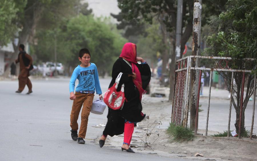 Local residents run away from the site of an attack with military vehicles in Kabul, Afghanistan on May 24, 2013. At least two suicide bombers and a policeman were killed and several others wounded on Friday evening when Taliban launched a coordinated attack in central Kabul, a police source said. (Xinhua/Ahmad Massoud) 