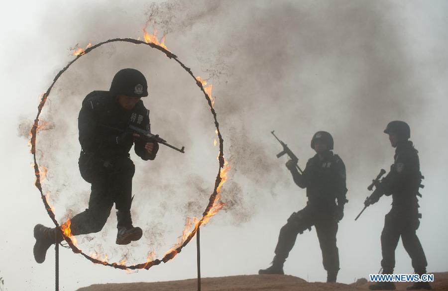 Members of SWAT (Special Weapons and Tactics) team receive training in the Jingning She Autonomous County, east China's Zhejiang Province, May 28, 2013. (Xinhua/Li Suren)