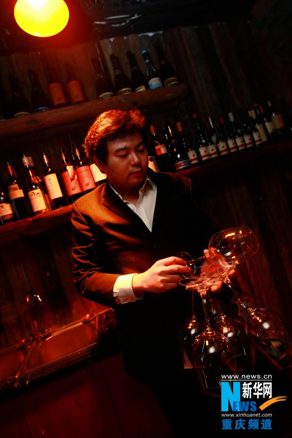 The owner tidies up wine sets at Haohe Chongqing wine club. (Photo/ Xinhua)